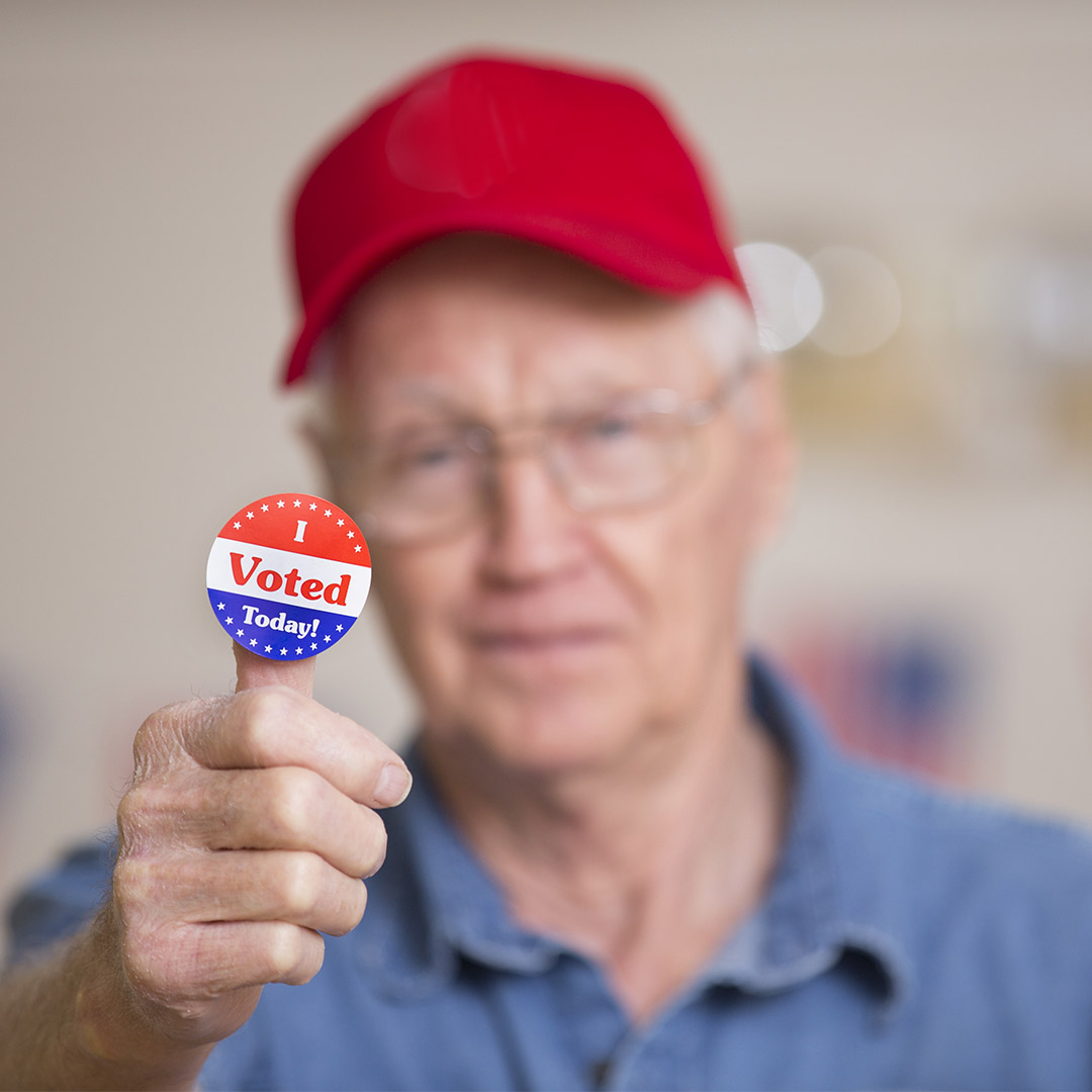 senior holding an I Voted sticker